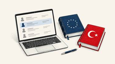 A laptop displaying customer records sits beside a navy law book with EU stars and a red law book with a white Turkish crescent and star.